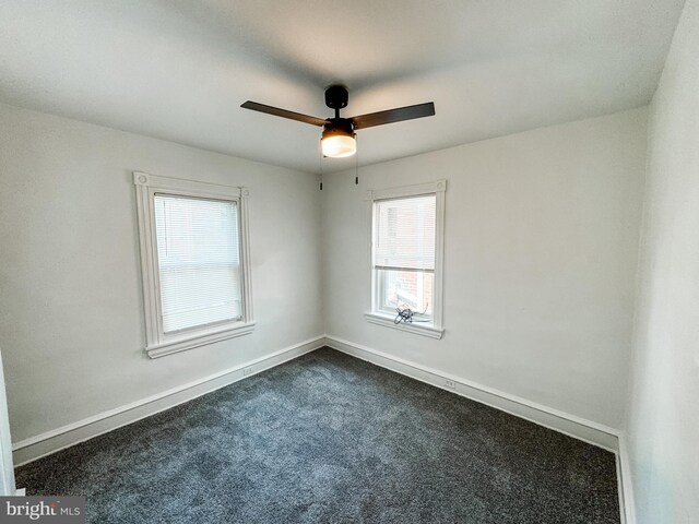 carpeted spare room featuring ceiling fan