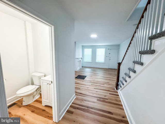 entrance foyer featuring baseboards, stairway, and light wood finished floors