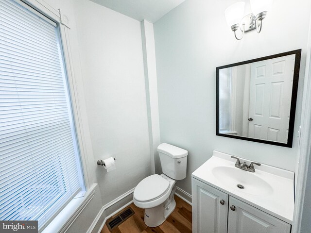 bathroom featuring hardwood / wood-style flooring, toilet, and vanity