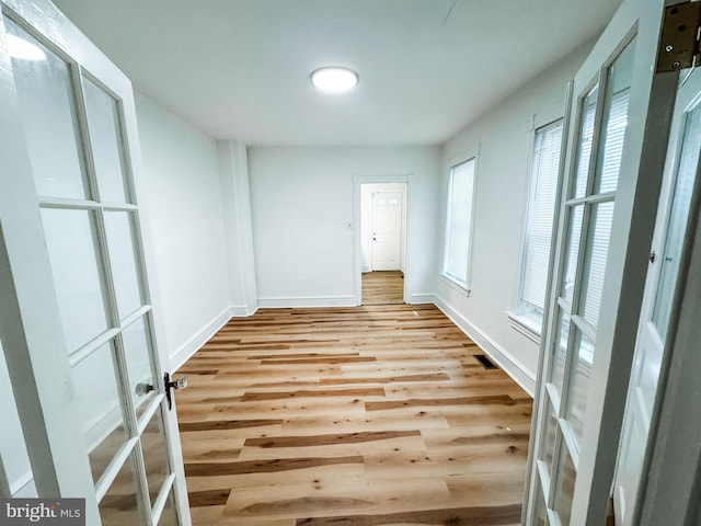 unfurnished room with light wood-style floors and baseboards