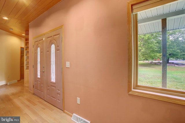 foyer featuring light wood-type flooring, plenty of natural light, and wood ceiling