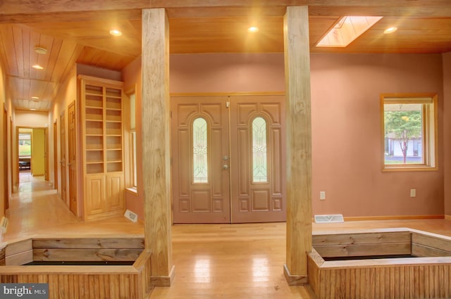 foyer featuring wooden ceiling, light hardwood / wood-style floors, and lofted ceiling with skylight