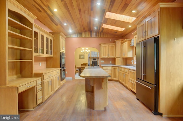 kitchen with light brown cabinets, a kitchen island, stainless steel appliances, lofted ceiling with skylight, and wooden ceiling