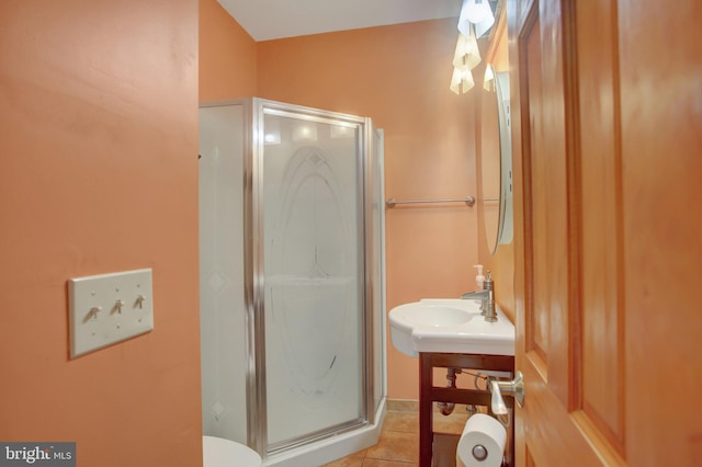 bathroom with toilet, a shower with shower door, and tile patterned flooring