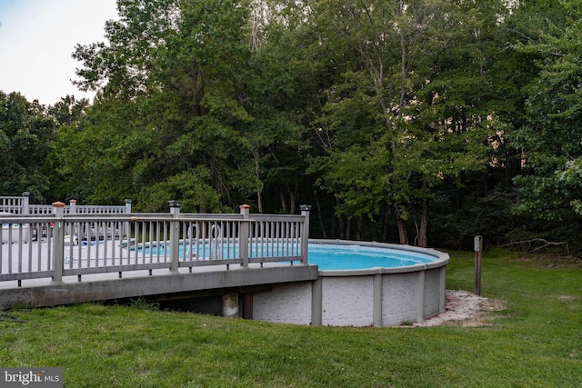 view of pool with a yard