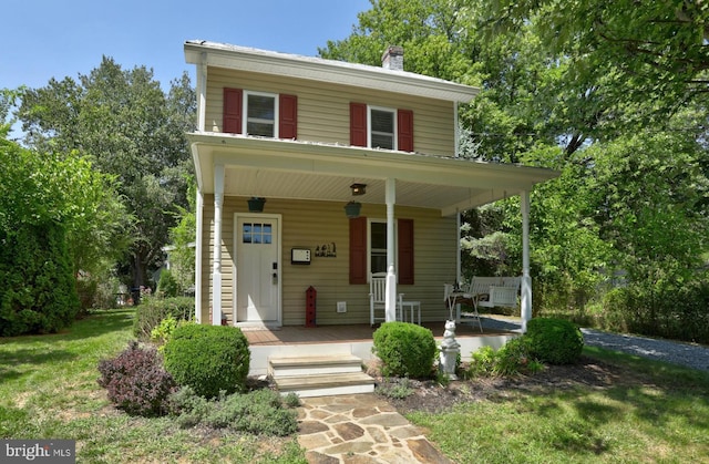 traditional style home with a porch and a chimney