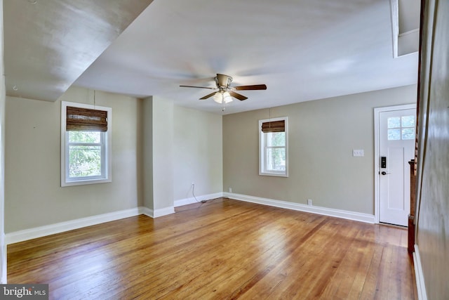 spare room with ceiling fan, hardwood / wood-style flooring, and a healthy amount of sunlight