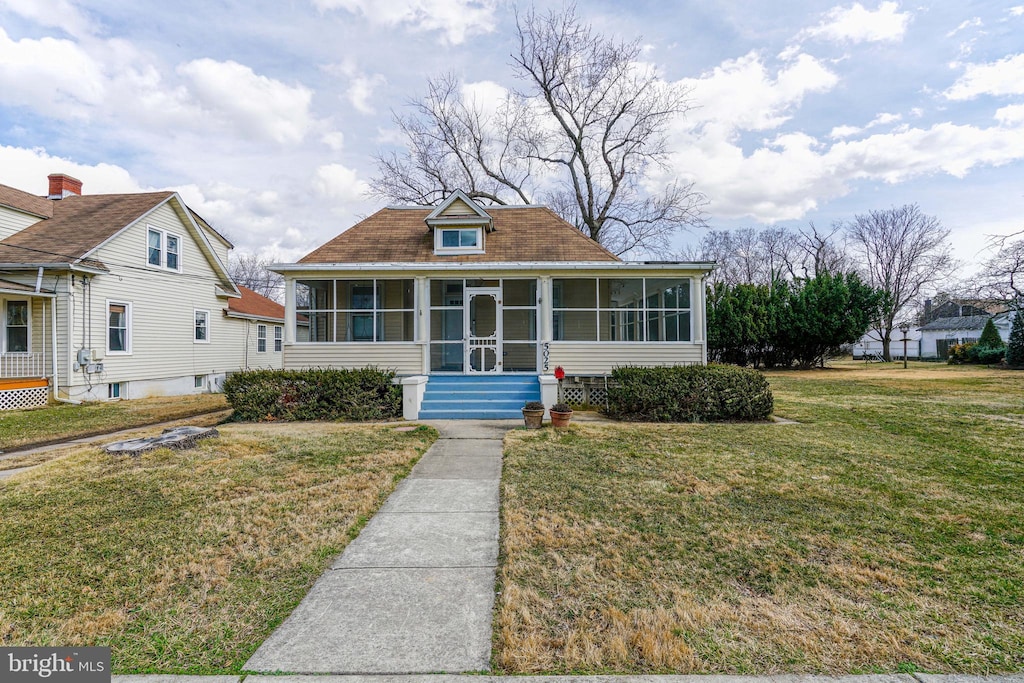 bungalow with a sunroom and a front lawn