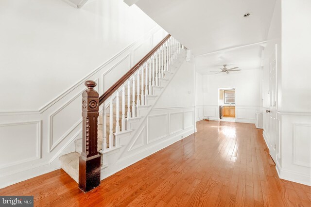 stairs featuring hardwood / wood-style floors and ceiling fan