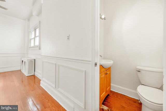 bathroom with wood-type flooring, toilet, and vanity