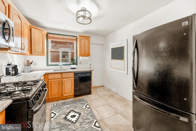 kitchen featuring sink, black appliances, light brown cabinetry, light tile patterned floors, and decorative backsplash