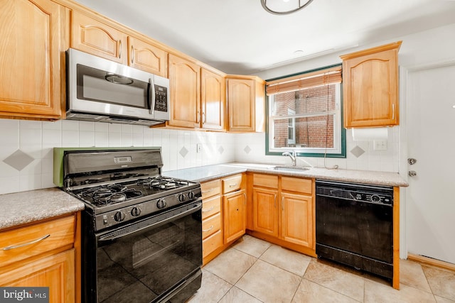 kitchen featuring backsplash, light tile patterned floors, black appliances, and sink