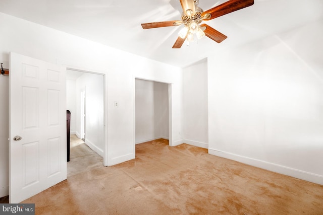 unfurnished bedroom featuring light carpet, ceiling fan, and a closet