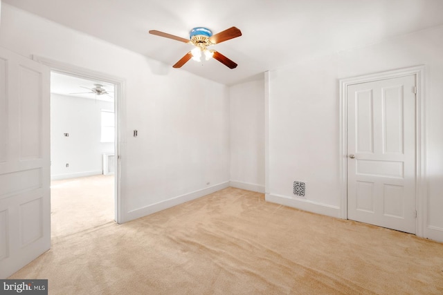 carpeted spare room with ceiling fan