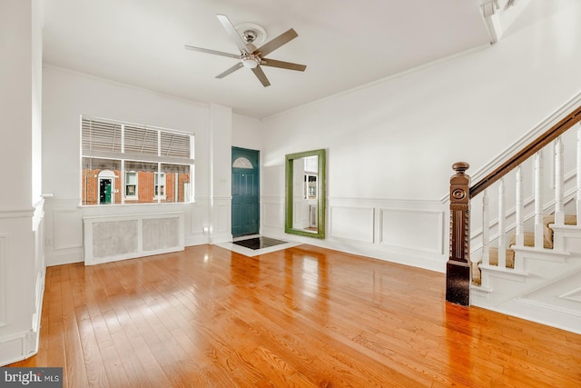 unfurnished living room with wood-type flooring, ceiling fan, and crown molding