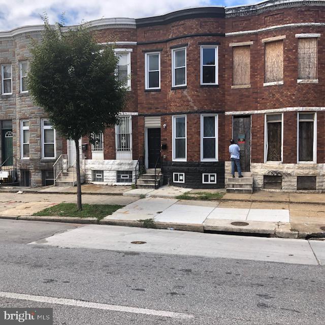 townhome / multi-family property featuring entry steps, stone siding, and brick siding