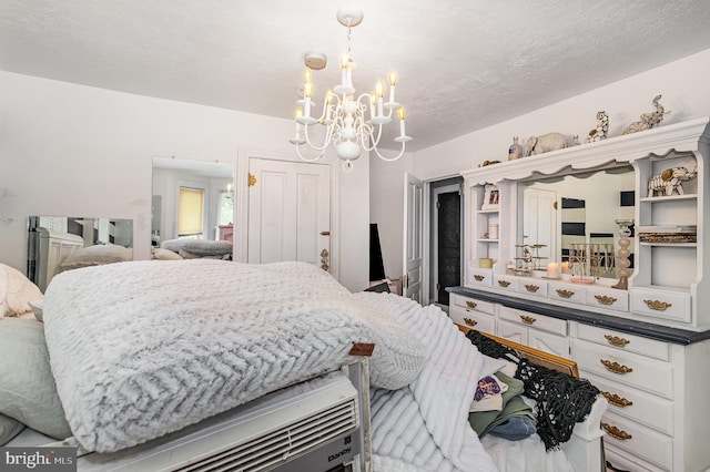 bedroom with a textured ceiling and a chandelier