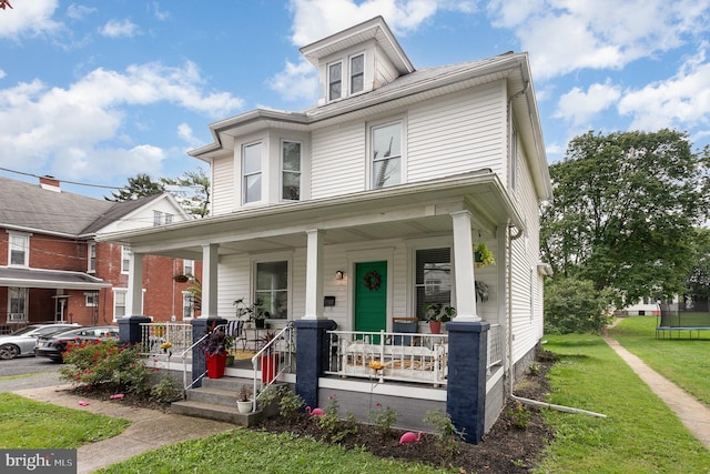 view of front facade with covered porch and a front lawn