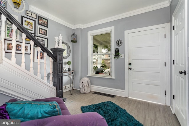 entrance foyer with light hardwood / wood-style flooring and ornamental molding