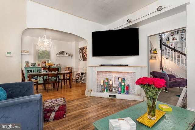 living room featuring wood-type flooring and an inviting chandelier