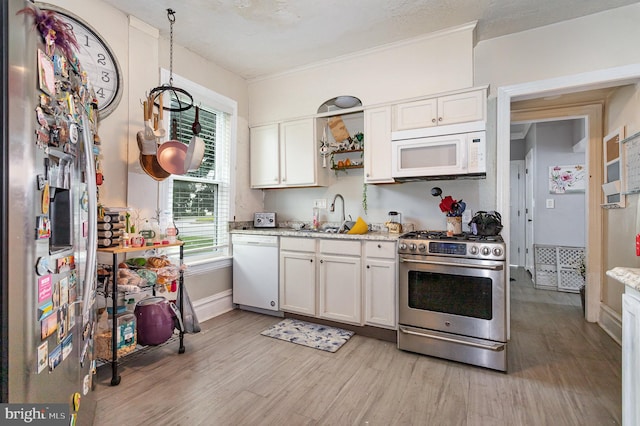 kitchen with sink, light stone counters, white appliances, light hardwood / wood-style floors, and white cabinets