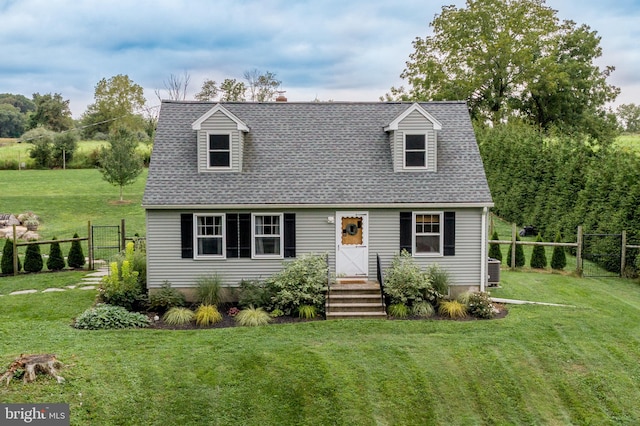 cape cod home featuring a front yard