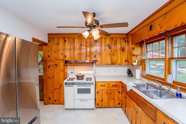 kitchen with ceiling fan, white range with gas stovetop, stainless steel refrigerator, and sink