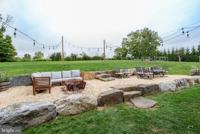 view of patio with an outdoor living space with a fire pit