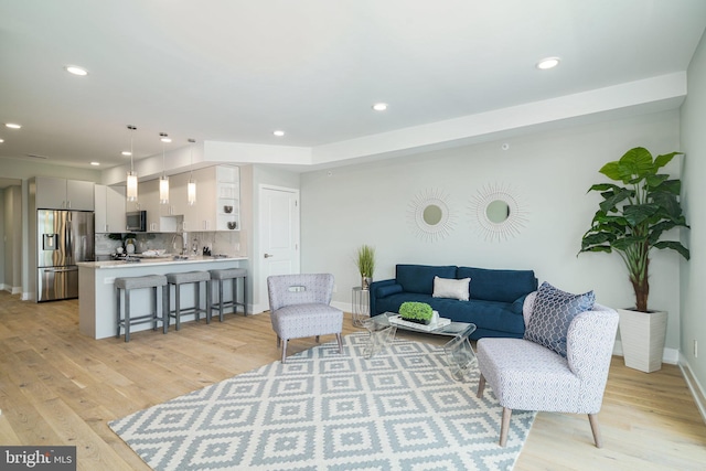 living room featuring light hardwood / wood-style floors and sink