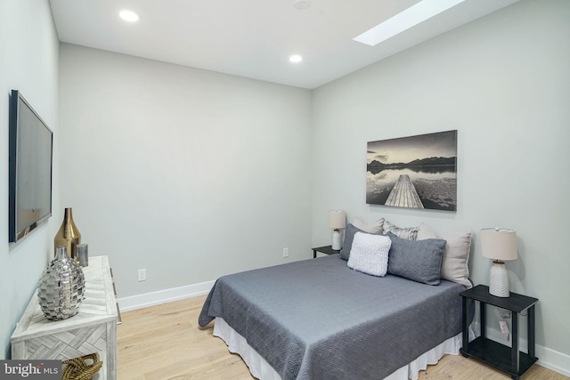 bedroom featuring light hardwood / wood-style floors and a skylight