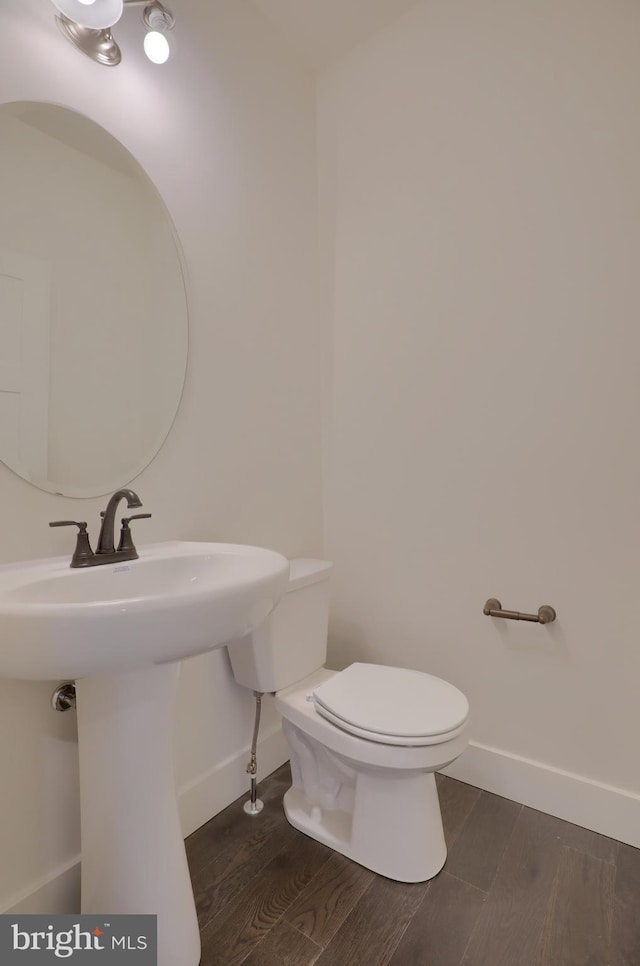 bathroom with hardwood / wood-style flooring and toilet