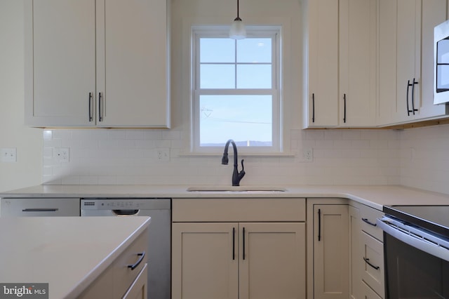 kitchen with sink, decorative light fixtures, backsplash, and dishwashing machine