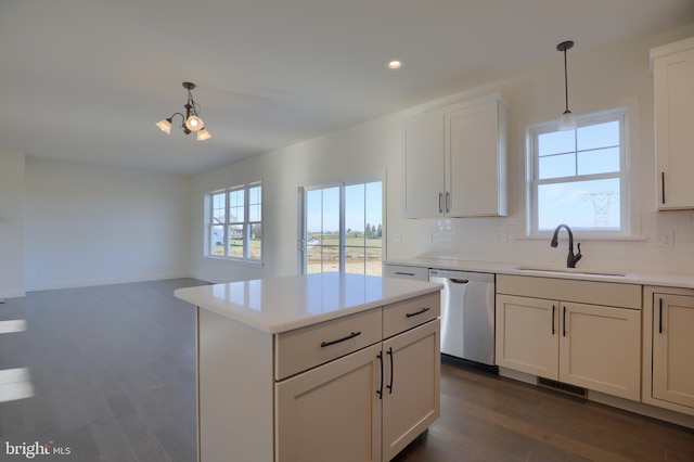 kitchen featuring sink, dark hardwood / wood-style flooring, decorative light fixtures, decorative backsplash, and dishwasher