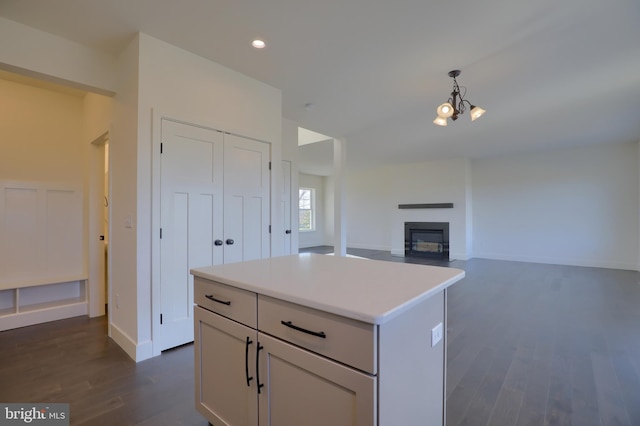 kitchen with dark wood-type flooring, pendant lighting, and a kitchen island