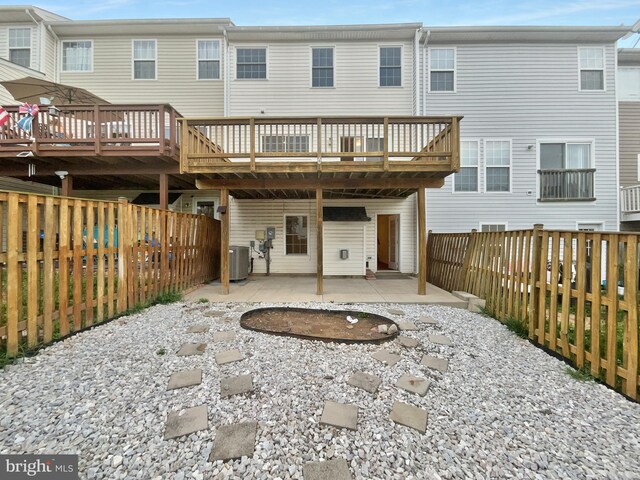 rear view of house featuring a deck, a patio area, and central AC