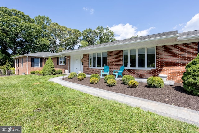 ranch-style home with brick siding and a front lawn