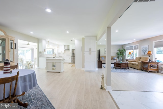 living room with sink, light hardwood / wood-style floors, and a healthy amount of sunlight