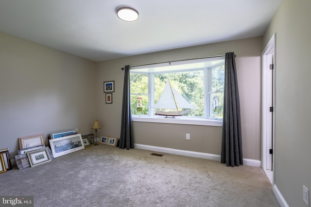 miscellaneous room featuring visible vents, light carpet, and baseboards