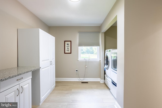 laundry area featuring laundry area, independent washer and dryer, light wood-style flooring, and baseboards