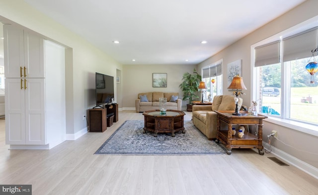 living area with light wood-style flooring, visible vents, baseboards, and recessed lighting