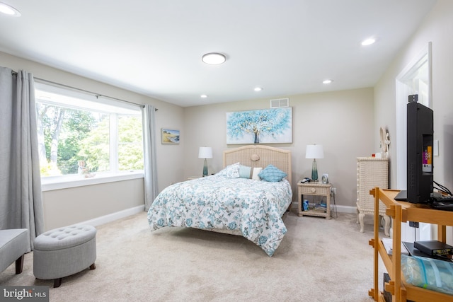 bedroom featuring visible vents, light carpet, and baseboards