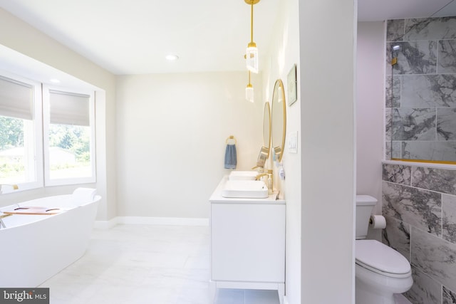 bathroom featuring toilet, a sink, a freestanding bath, marble finish floor, and double vanity