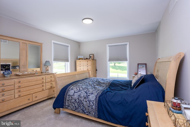 bedroom with light carpet and visible vents