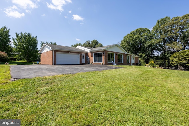 ranch-style house featuring a garage and a front lawn