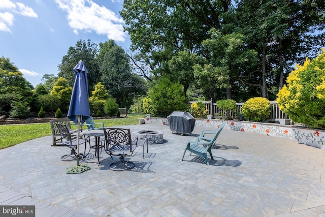 view of patio featuring an outdoor fire pit and a grill