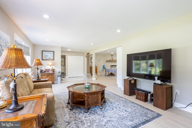 living room with recessed lighting, light wood-style flooring, and baseboards