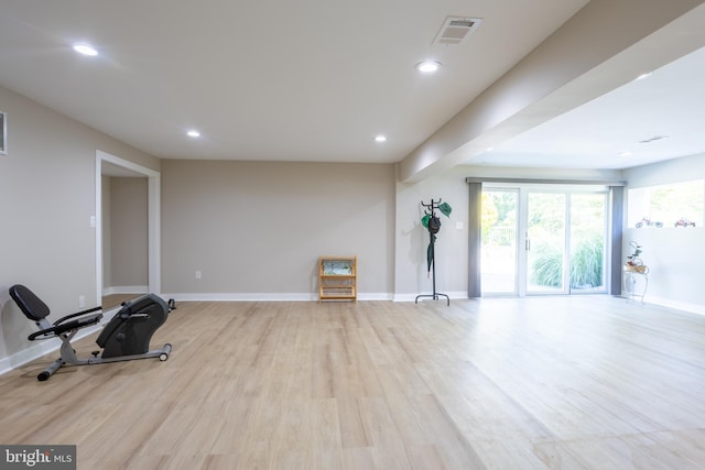 exercise room with light hardwood / wood-style flooring