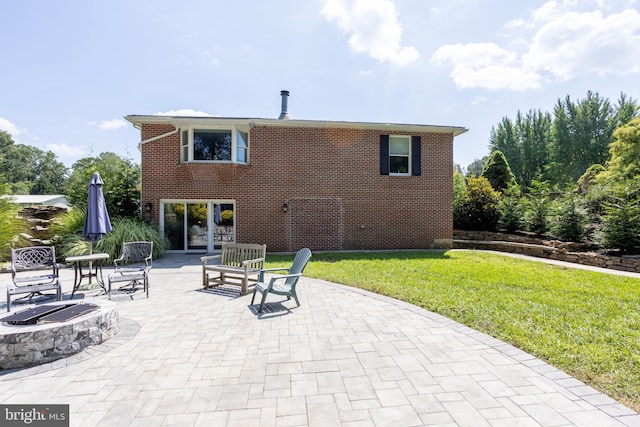 rear view of house with brick siding, a patio, a fire pit, and a lawn