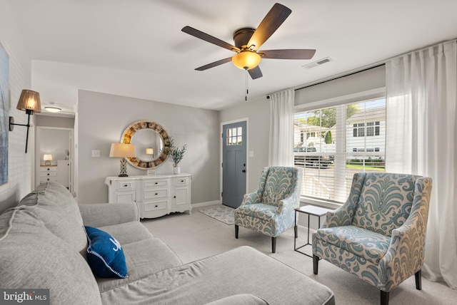 carpeted living room with ceiling fan