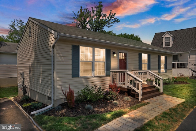 view of front of property with a yard and a deck